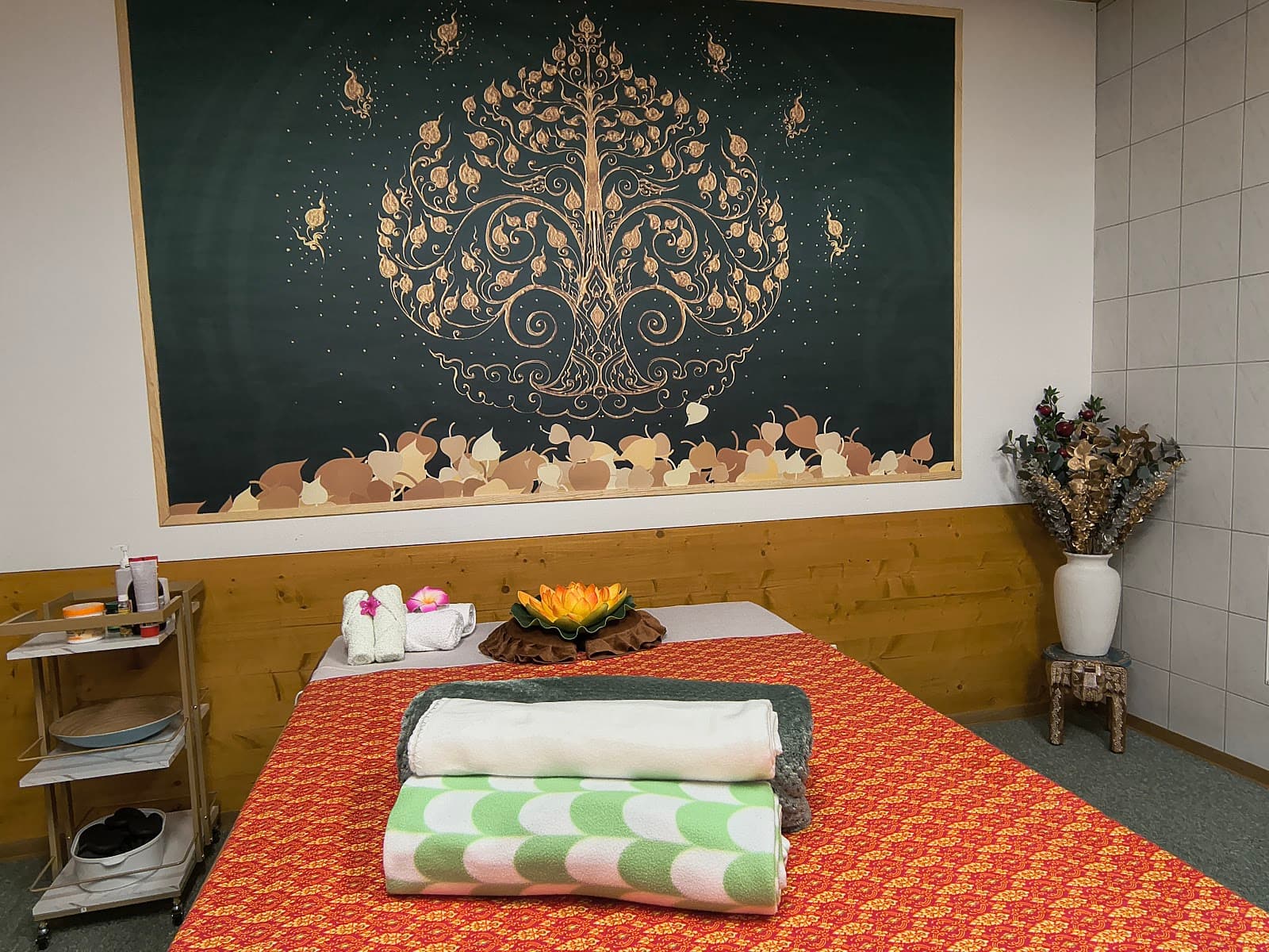 Orathai Behandlungsraum mit Massageliege und Thai-Mural
